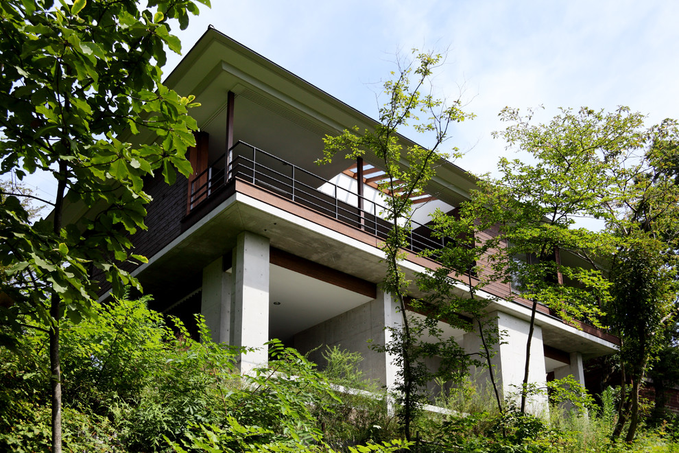 Foto della villa marrone contemporanea a due piani di medie dimensioni con rivestimento in cemento, tetto a padiglione e copertura in metallo o lamiera