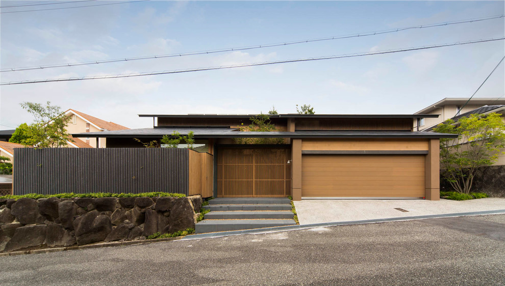 Cette photo montre une façade de maison marron asiatique avec un toit plat.