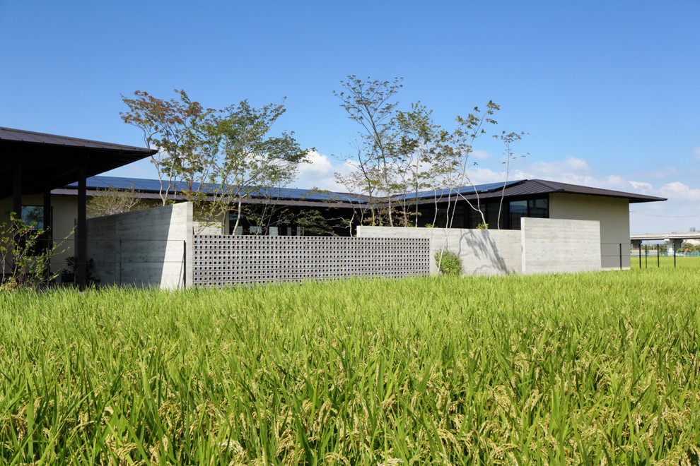 Modelo de fachada gris moderna grande de una planta con tejado a cuatro aguas