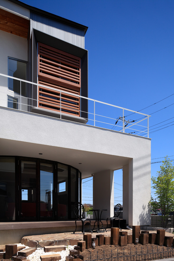 Cette photo montre une façade de maison blanche tendance à un étage avec un toit en appentis et un toit en métal.