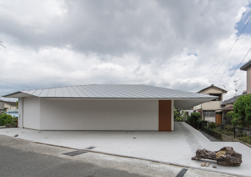 Cette photo montre une façade de maison blanche moderne de plain-pied avec un toit à deux pans.