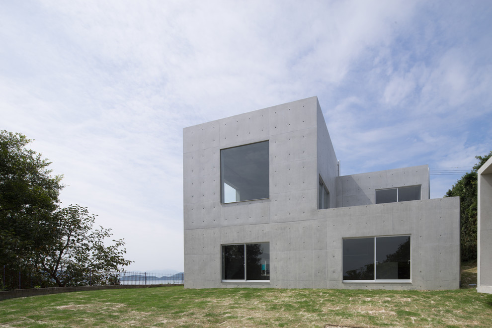 Modelo de fachada gris minimalista con revestimiento de hormigón y tejado plano