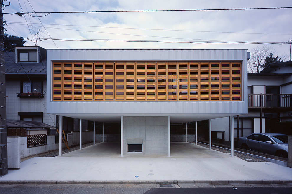 Cette photo montre une façade de maison grise tendance avec un toit plat.