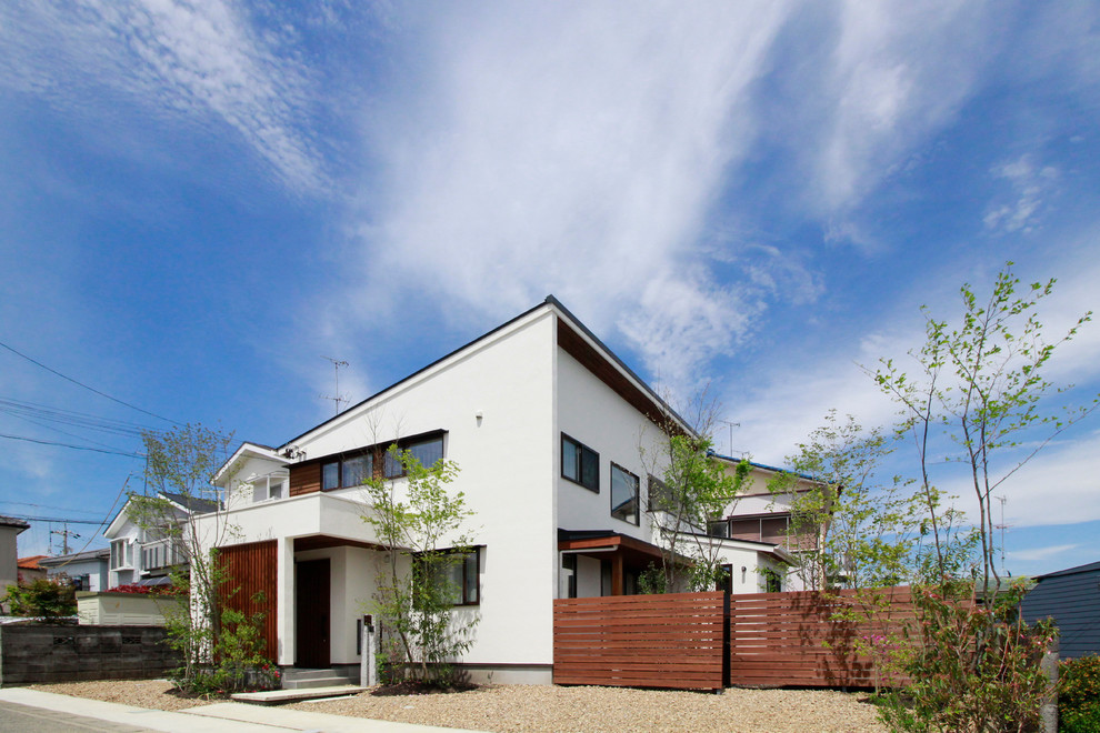 Zweistöckiges Asiatisches Einfamilienhaus mit weißer Fassadenfarbe und Pultdach in Sonstige