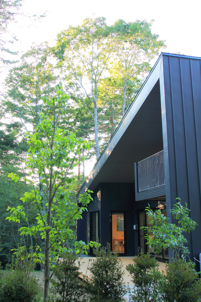 Idées déco pour une façade de maison grise moderne de taille moyenne et à un étage avec un toit en appentis et un toit en métal.