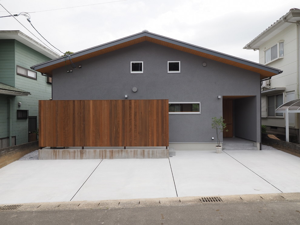 На фото: серый частный загородный дом в стиле модернизм с двускатной крышей с
