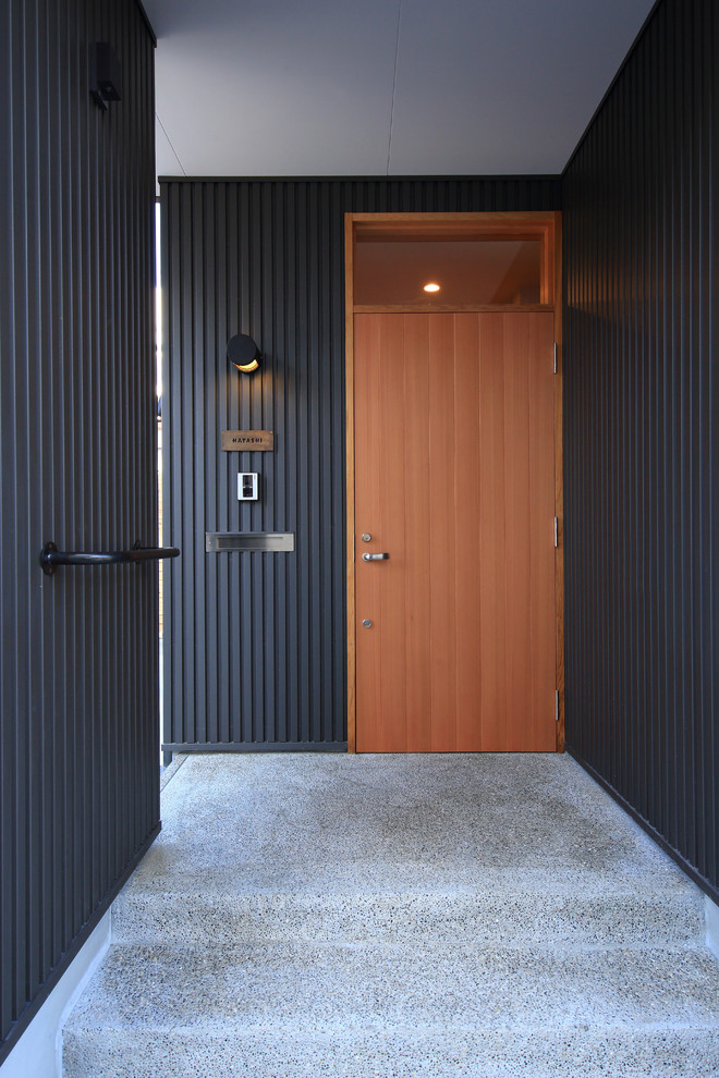 Réalisation d'une façade de maison noire minimaliste à un étage avec un toit en métal et un toit à deux pans.