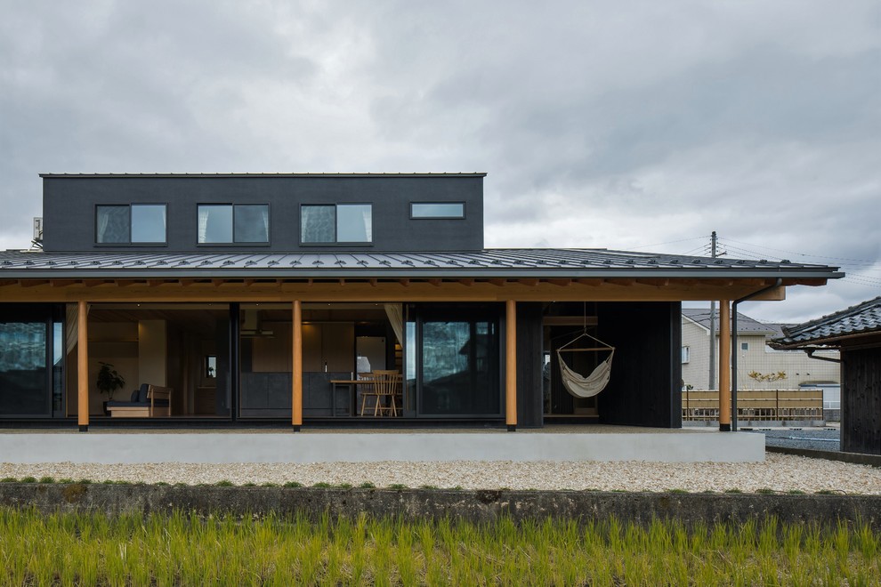 Foto de fachada de casa negra retro de tamaño medio de dos plantas con revestimiento de madera, tejado a dos aguas y tejado de metal