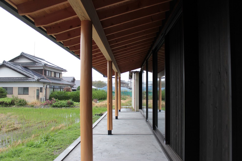 Imagen de fachada de casa negra de estilo zen grande de dos plantas con revestimiento de madera, tejado a dos aguas y tejado de metal