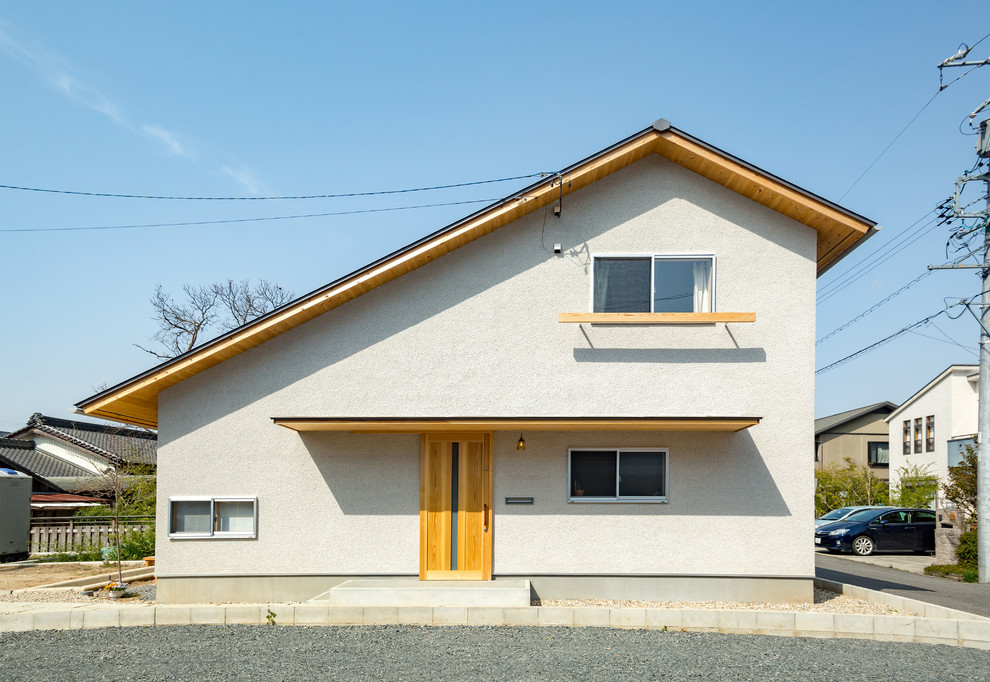 Asiatisches Haus mit weißer Fassadenfarbe und Satteldach in Sonstige