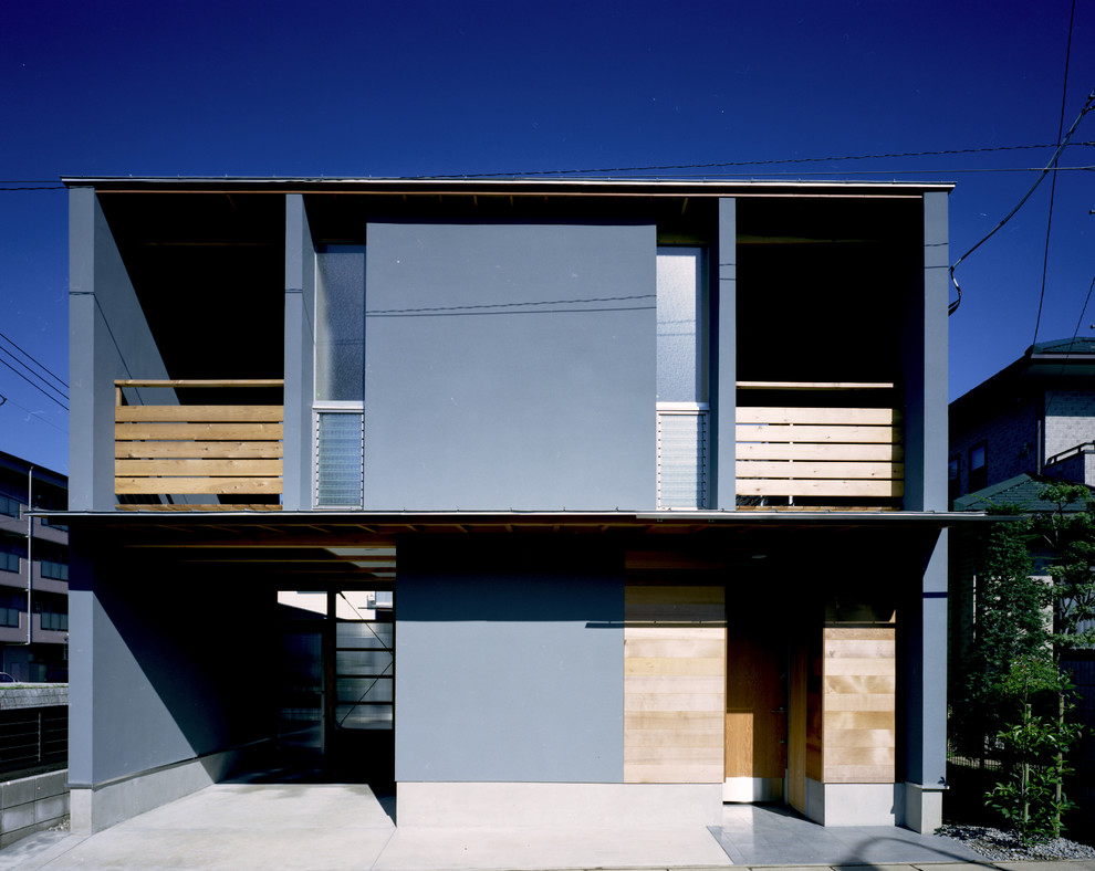Mittelgroßes, Zweistöckiges Modernes Einfamilienhaus mit Putzfassade, grauer Fassadenfarbe, Pultdach und Blechdach in Tokio