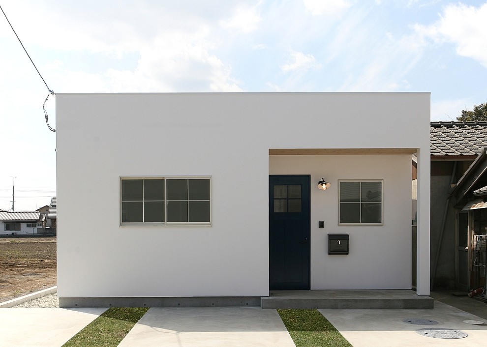 Exemple d'une façade de maison blanche scandinave avec un toit plat.