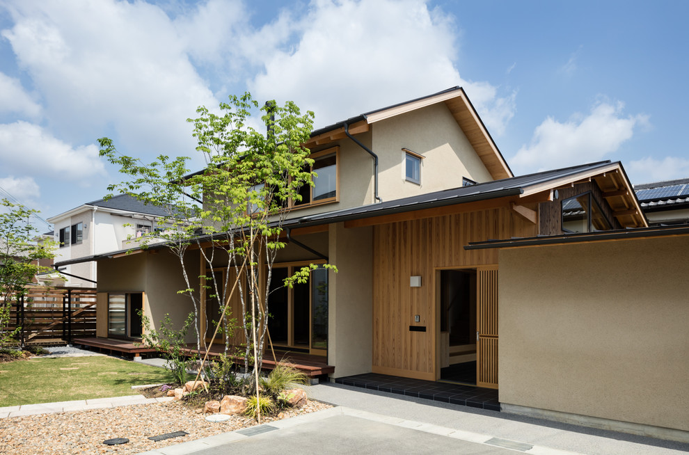 На фото: двухэтажный, бежевый, деревянный частный загородный дом в восточном стиле с двускатной крышей и металлической крышей с