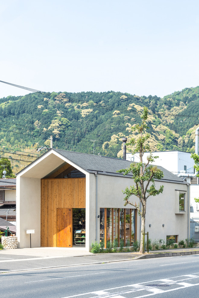 Cette photo montre une façade de maison blanche asiatique à un étage avec un revêtement mixte, un toit à deux pans et un toit en shingle.