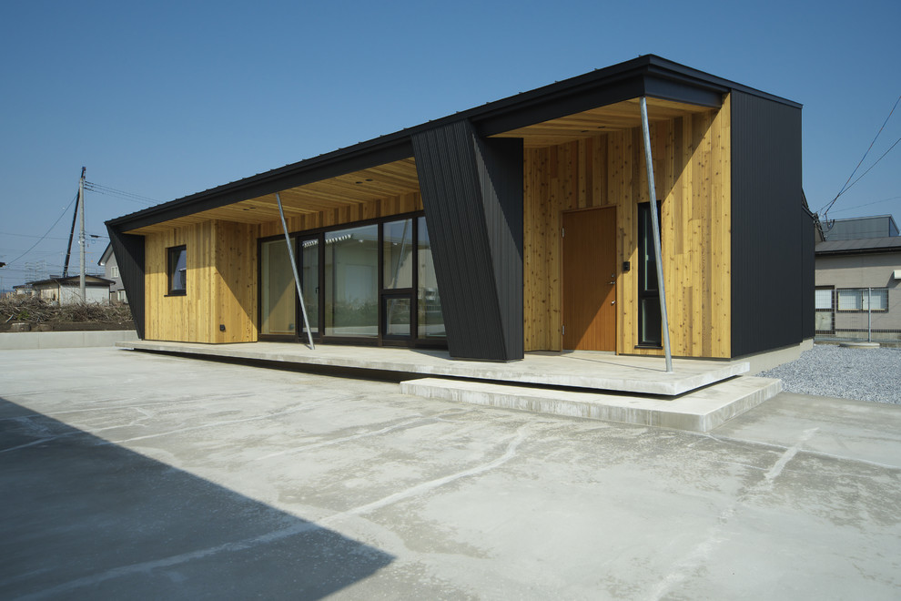 Cette photo montre une façade de maison noire asiatique avec un toit en appentis.