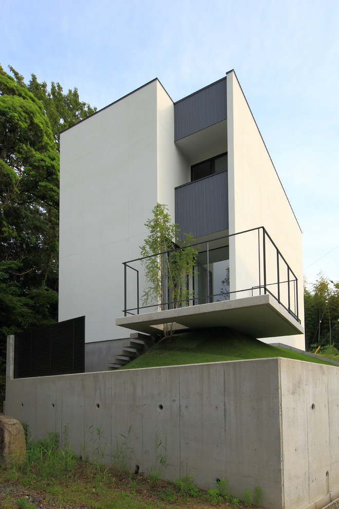 Exemple d'une façade de maison blanche moderne à un étage.