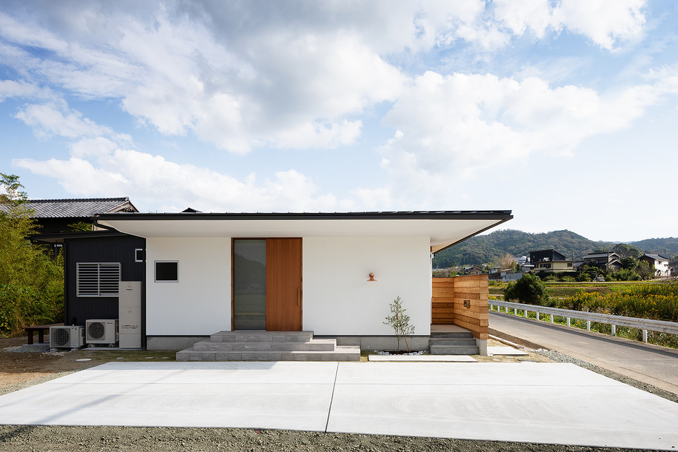 Cette photo montre une façade de maison blanche scandinave en planches et couvre-joints de plain-pied et de taille moyenne avec un toit en appentis, un toit en métal, un revêtement mixte et un toit noir.