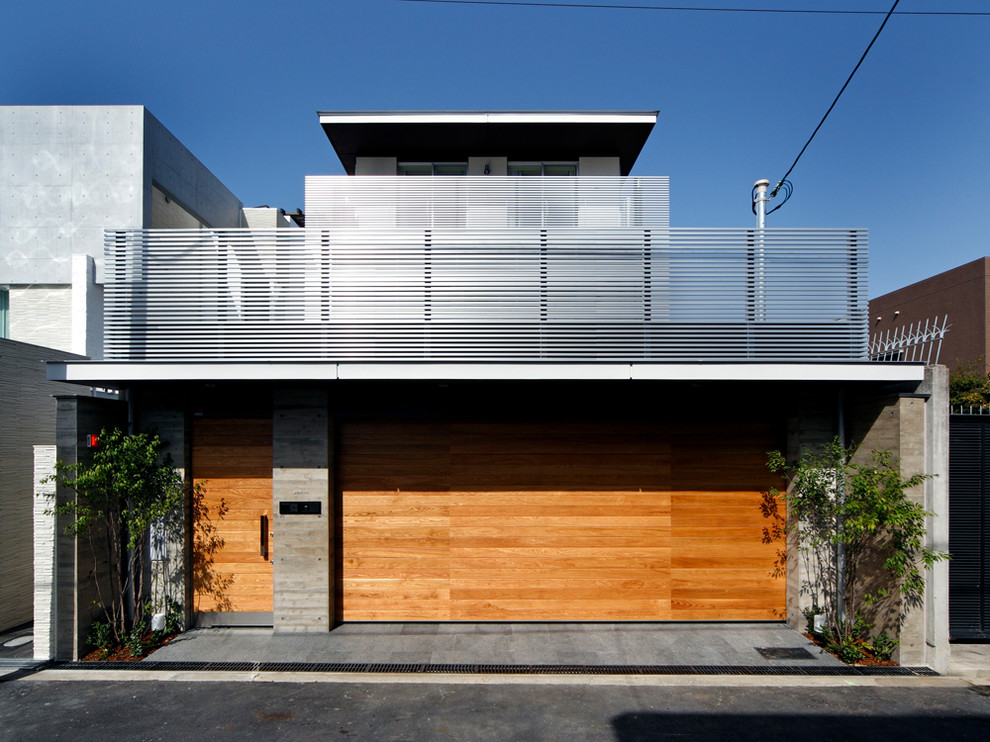 Dreistöckiges Modernes Haus mit grauer Fassadenfarbe und Flachdach in Osaka