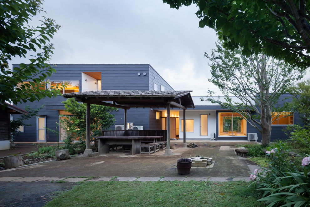 Cette image montre une grande façade de maison blanche minimaliste en stuc à un étage avec un toit en appentis et un toit en métal.