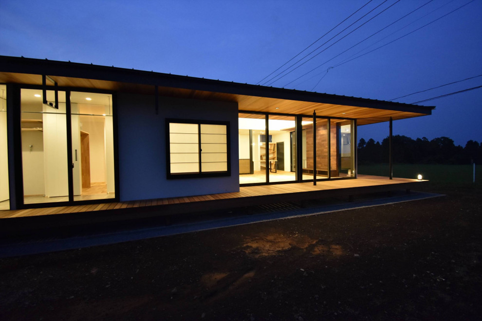 На фото: одноэтажный, черный частный загородный дом среднего размера в стиле лофт с облицовкой из металла, двускатной крышей и металлической крышей с
