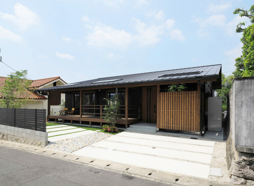 Photo of a small and black modern bungalow detached house in Other with metal cladding, a hip roof and a metal roof.