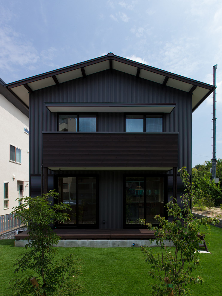 Modelo de fachada negra minimalista con tejado a dos aguas