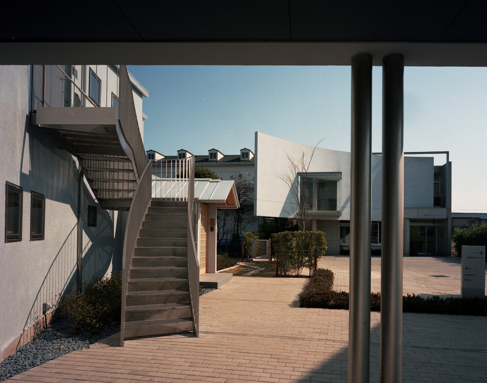 На фото: двухэтажный, бежевый частный загородный дом среднего размера в стиле модернизм с односкатной крышей и металлической крышей с