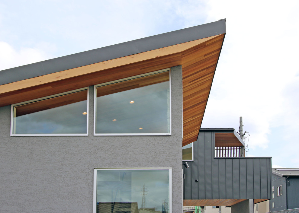 Idéer för ett modernt grått hus, med två våningar, pulpettak och tak i metall