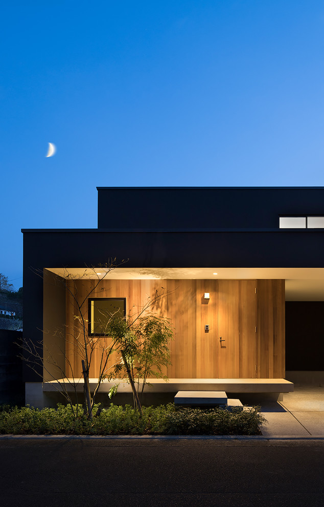 На фото: большой, двухэтажный, черный частный загородный дом в стиле модернизм с односкатной крышей и металлической крышей с