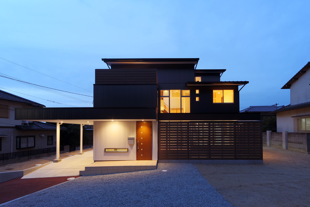 Modernes Haus mit Mix-Fassade, schwarzer Fassadenfarbe und Flachdach in Sonstige