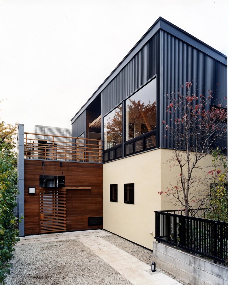 Diseño de fachada de casa negra contemporánea de dos plantas con revestimiento de metal y tejado de un solo tendido