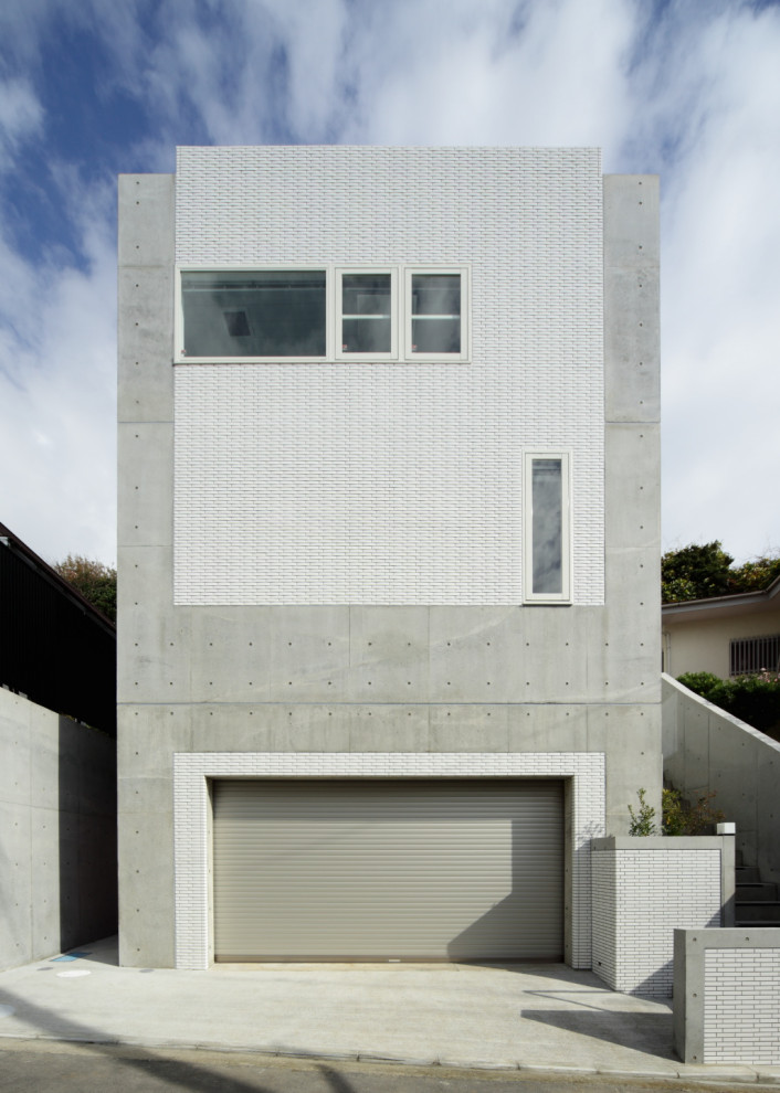 Photo of a medium sized and gey modern detached house in Other with three floors and a flat roof.