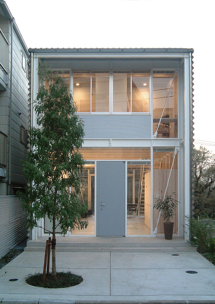 Zweistöckiges Industrial Haus mit grauer Fassadenfarbe und Flachdach in Tokio