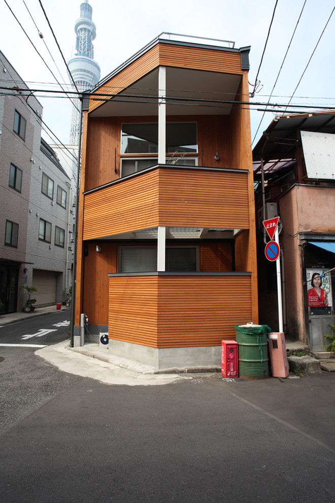 Mittelgroßes Country Haus mit brauner Fassadenfarbe und Flachdach in Tokio