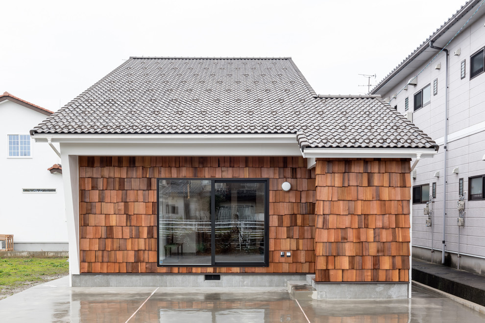 Idées déco pour une façade de maison marron moderne en bois de taille moyenne et à un étage avec un toit en appentis et un toit en tuile.