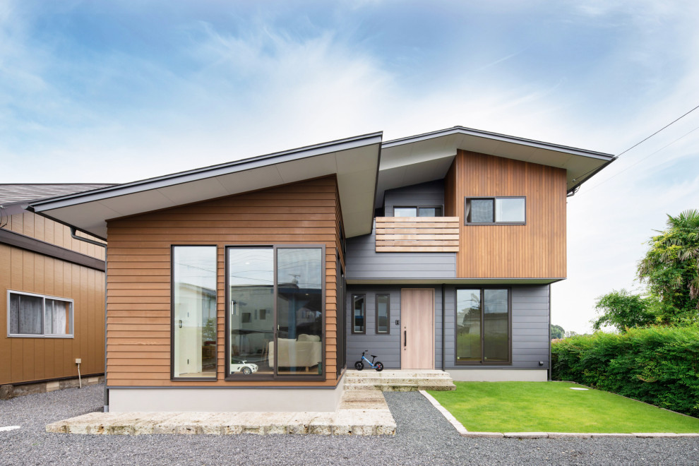 Inspiration pour une façade de maison multicolore design à un étage avec un toit à deux pans.