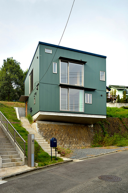 Idées déco pour une façade de maison verte moderne à un étage avec un toit en appentis.