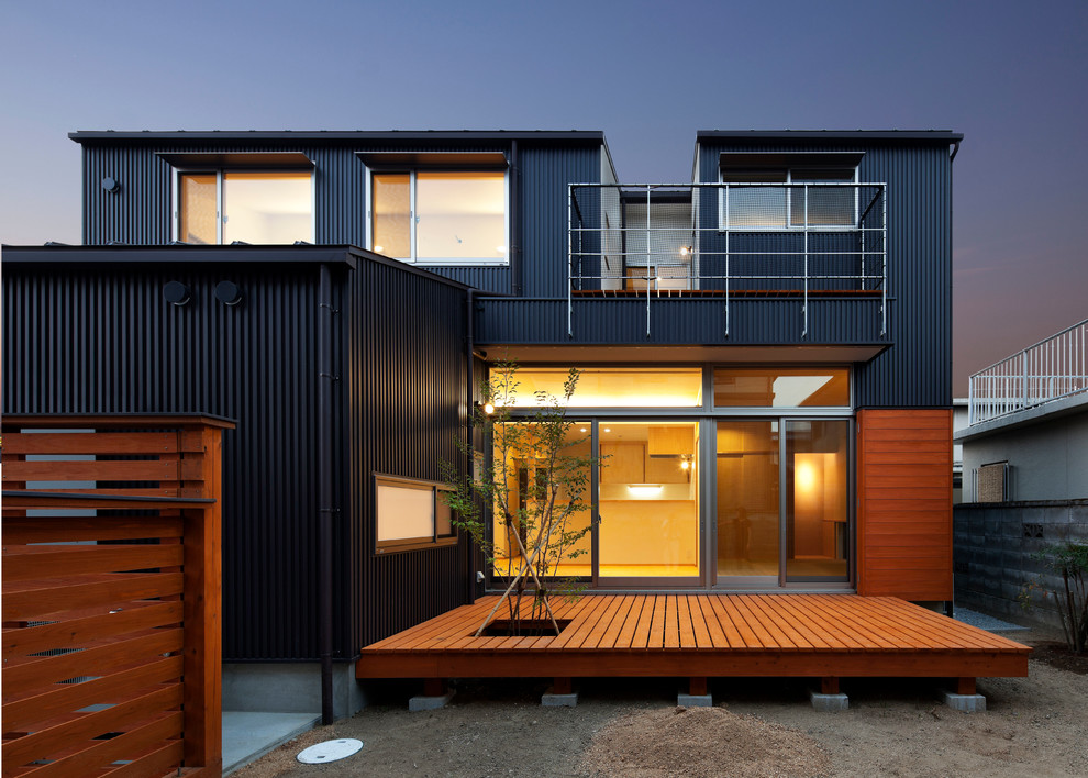 На фото: двухэтажный, черный, большой дом в современном стиле с облицовкой из металла