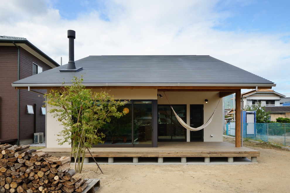 Inspiration för ett mellanstort beige hus, med pulpettak, tak i metall, två våningar och blandad fasad