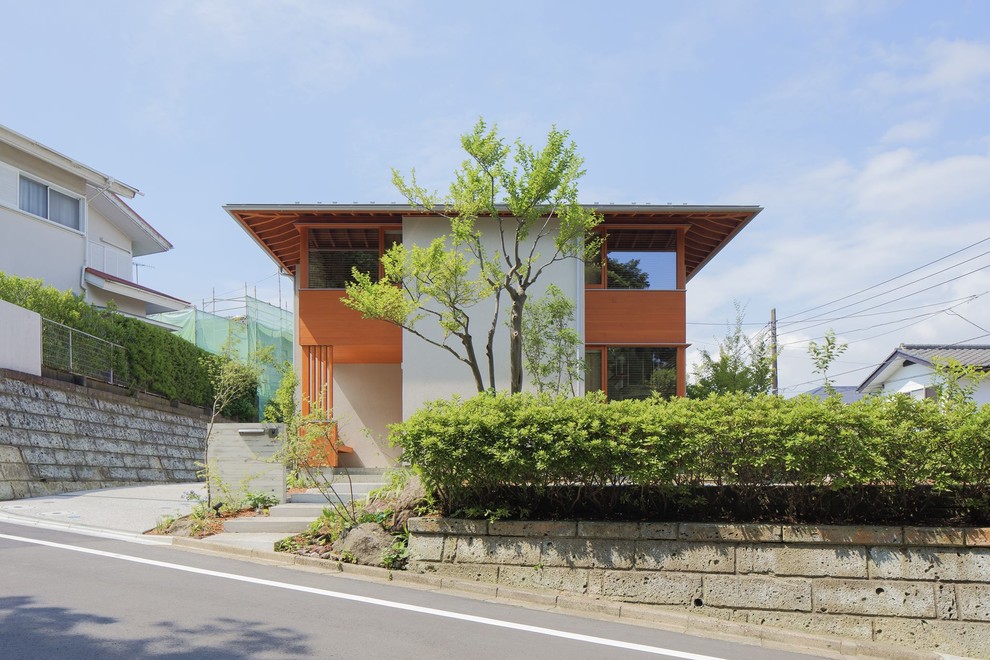 Mittelgroßes Skandinavisches Einfamilienhaus mit Putzfassade, weißer Fassadenfarbe, Walmdach und Blechdach in Yokohama