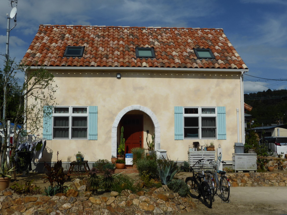 他の地域にある中くらいな地中海スタイルのおしゃれな家の外観 (漆喰サイディング、黄色い外壁) の写真
