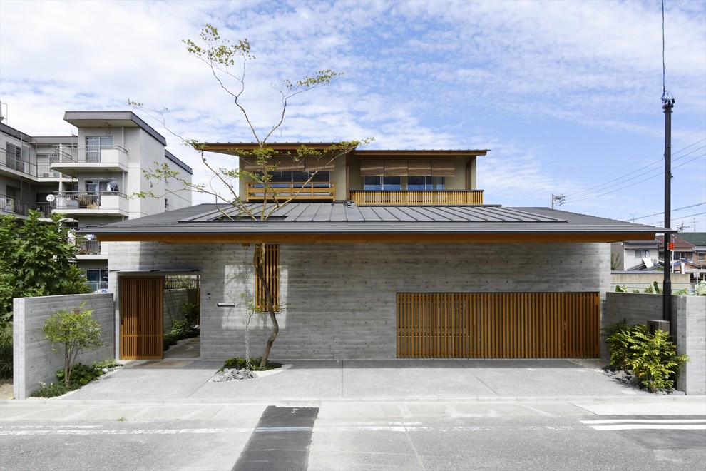 Diseño de fachada gris de estilo zen de dos plantas con revestimiento de ladrillo y tejado plano