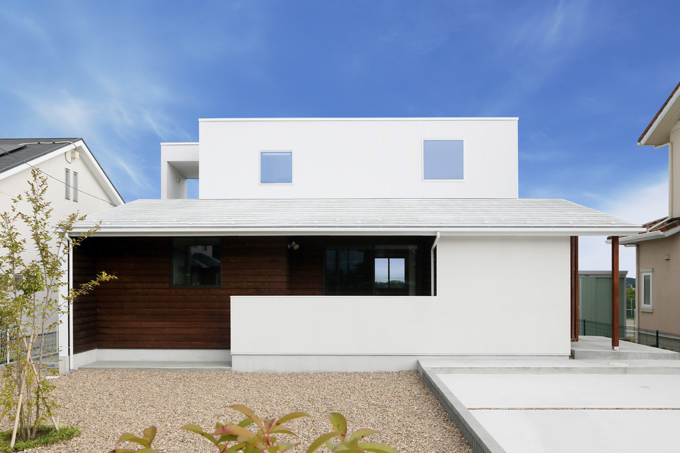 Idée de décoration pour une façade de maison blanche design à un étage avec un toit plat.