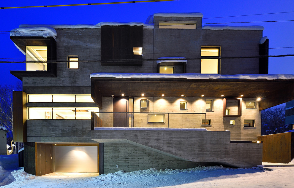 Imagen de fachada gris contemporánea de dos plantas con revestimiento de hormigón y tejado plano