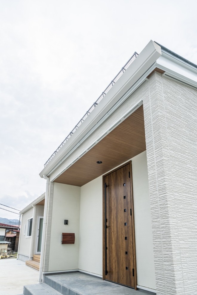 Inspiration pour une façade de maison beige minimaliste en béton de taille moyenne et de plain-pied avec un toit en appentis et un toit en métal.