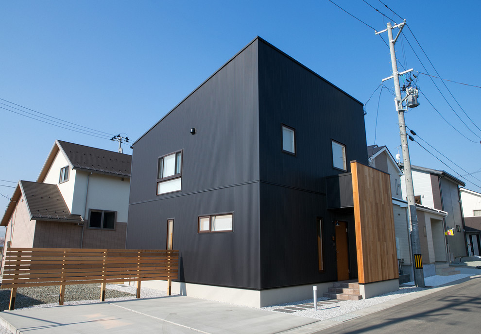 Inspiration för små industriella svarta hus, med två våningar, metallfasad, pulpettak och tak i metall