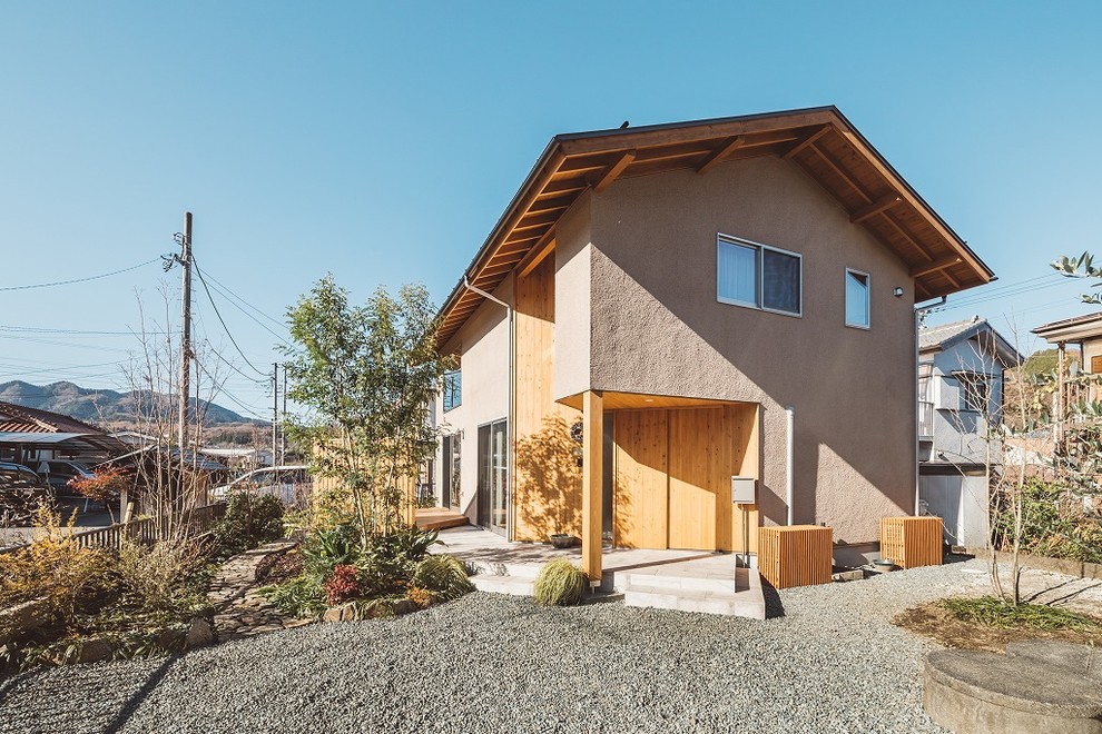 Imagen de fachada de casa marrón de estilo zen de dos plantas con tejado a dos aguas