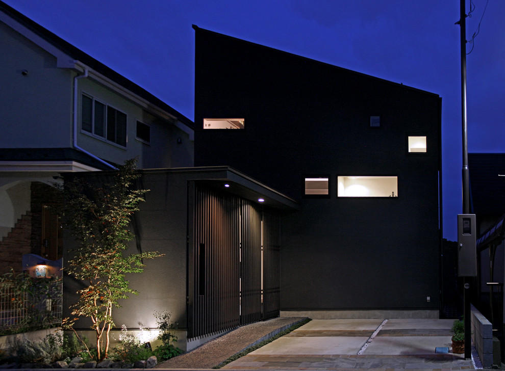 Aménagement d'une façade de maison noire asiatique en stuc de taille moyenne et à un étage avec un toit en appentis et un toit en métal.