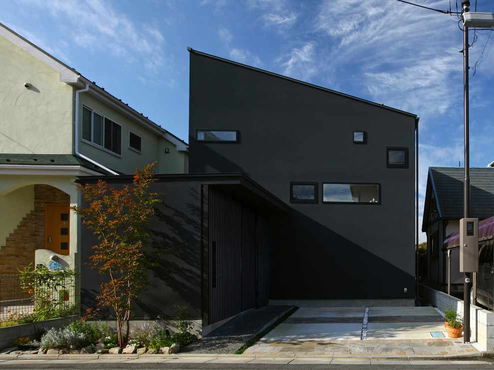 Inspiration för ett mellanstort orientaliskt svart hus, med två våningar, stuckatur, pulpettak och tak i metall