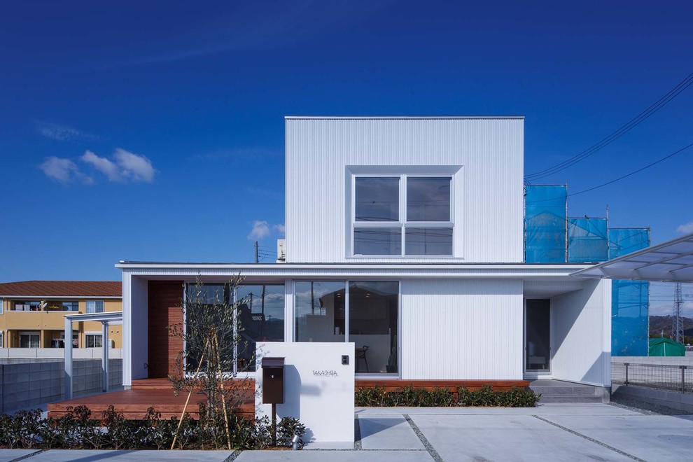 Idées déco pour une façade de maison blanche et métallique contemporaine de taille moyenne et à un étage avec un toit en appentis et un toit en métal.